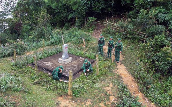Cán bộ, chiến sỹ Đồn Biên phòng Chiềng Tương (Bộ Chỉ huy Bộ đội Biên phòng tỉnh Sơn La) phát cỏ, vệ sinh cảnh quan quanh khu vực mốc giới quốc gia. Ảnh: Quang Quyết-TTXVN