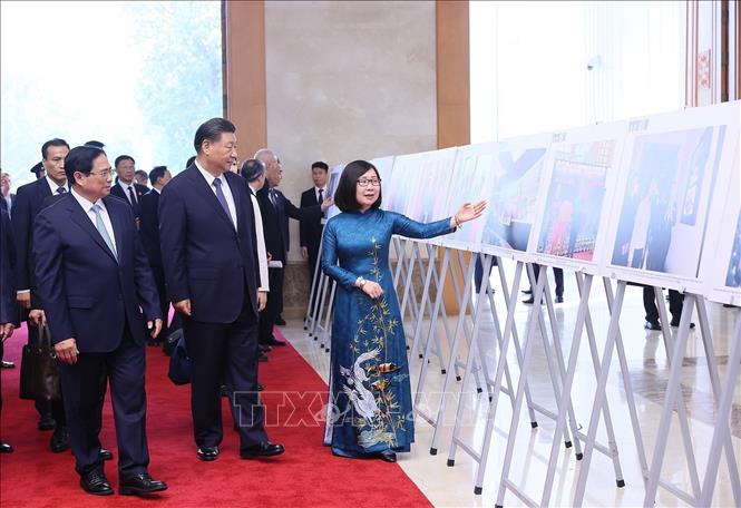 Prime Minister Pham Minh Chinh and Chinese Party General Secretary and President Xi Jinping look at typical photos of Vietnam-China relations at the Government headquarters in Hanoi on December 13. VNA Photo: Dương Giang
