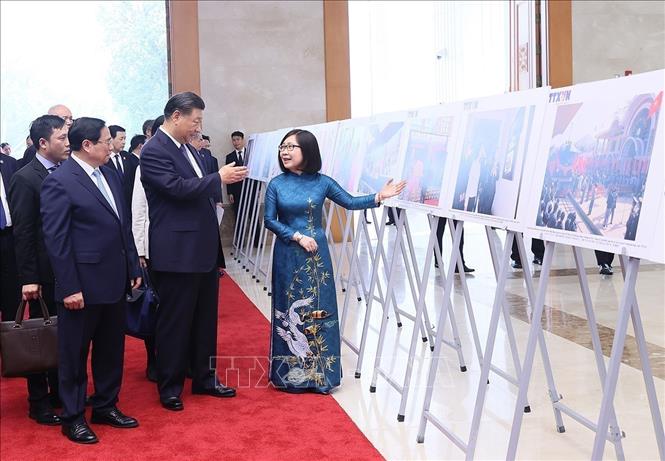 Prime Minister Pham Minh Chinh and Chinese Party General Secretary and President Xi Jinping look at typical photos of Vietnam-China relations at the Government headquarters in Hanoi on December 13. VNA Photo: Dương Giang