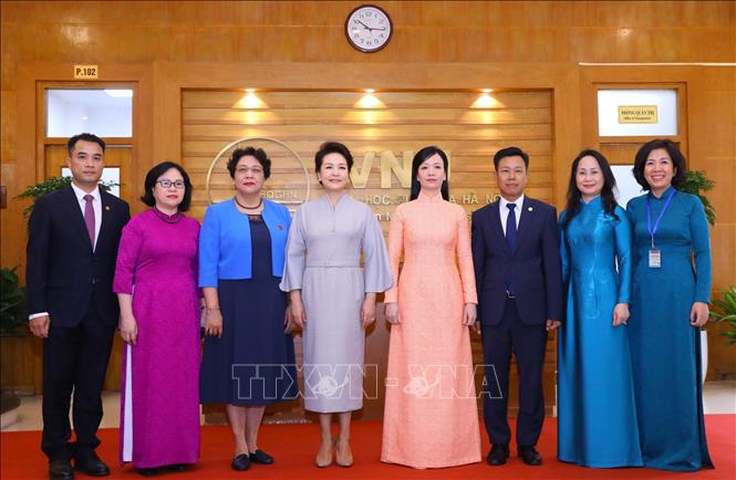 Bà Phan Thị Thanh Tâm, Phu nhân Chủ tịch nước Võ Văn Thưởng và bà Bành Lệ Viên, Phu nhân Tổng Bí thư, Chủ tịch nước Trung Quốc chụp ảnh chung với Ban lãnh đạo Đại học Quốc gia Hà Nội. Ảnh: Văn Điệp - TTXVN
