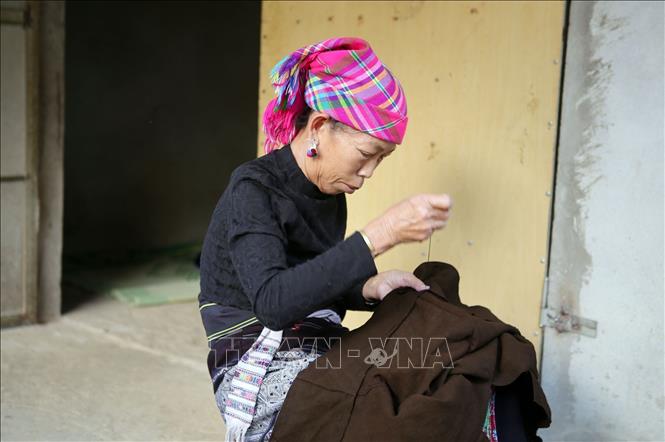 Phụ nữ dân tộc Lự vốn cần cù, chịu khó nên mỗi khi nông nhàn lại đem vải ra khâu váy, áo. Ảnh: Quý Trung – TTXVN