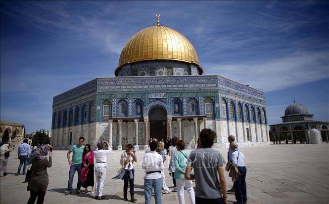 Khách du lịch chụp ảnh bên ngoài Thánh đường Hồi giáo tại thành cổ Jerusalem. Ảnh: AFP/TTXVN