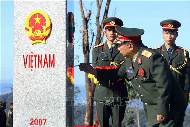 Đại tướng Chansamone Chanyalath, Phó Thủ tướng Chính phủ, Bộ trưởng Bộ Quốc phòng Lào tô son cột mốc chủ quyền tại cột mốc ngã ba biên giới Việt Nam - Lào - Campuchia. Ảnh: An Đăng - TTXVN