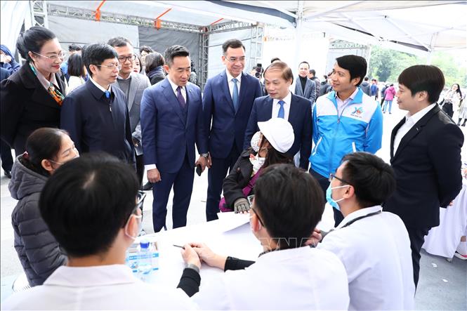 Đồng chí Phạm Tất Thắng, Phó trưởng ban thường trực Ban Dân vận Trung ương; anh Nguyễn Ngọc Lương, Bí thư thường trực Trung ương Đoàn, Chủ tịch Hội Liên hiệp Thanh niên Việt Nam cùng các đại biểu thăm hỏi, động viên người dân đi khám bệnh. Ảnh: Minh Đức - TTXVN