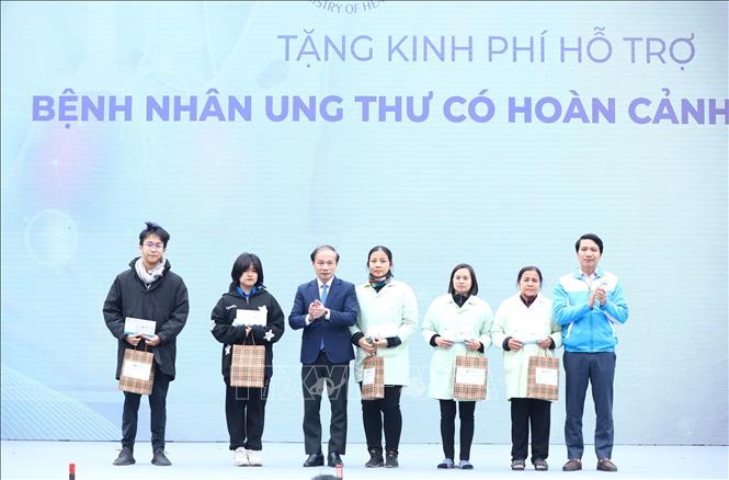 Đồng chí Phạm Tất Thắng, Phó trưởng ban thường trực Ban Dân vận Trung ương; anh Nguyễn Ngọc Lương, Bí thư thường trực Trung ương Đoàn, Chủ tịch Hội Liên hiệp Thanh niên Việt Nam trao tặng các phần tiền hỗ trợ cho đại diện các gia đình có bệnh nhân ung thư. Ảnh: Minh Đức - TTXVN