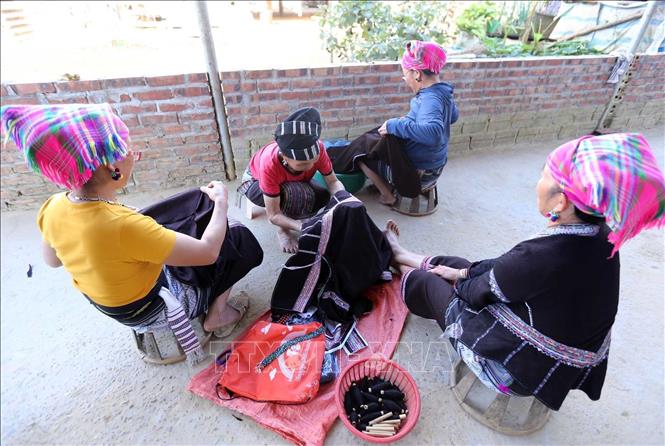 In their free time, Lu women tend to their sewing and mending clothes for loved ones. VNA Photo: Quý Trung