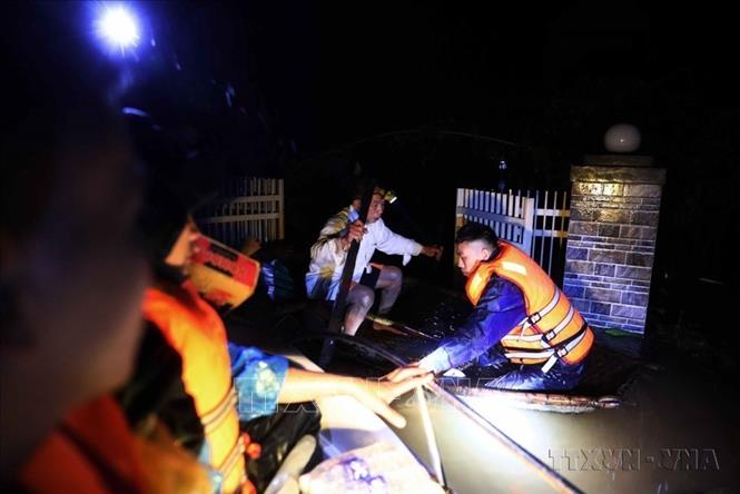 Lực lượng quân đội tỉnh Hà Tĩnh dùng thuyền tới cứu trợ người dân bị cô lập do lũ lụt tại thôn Ngũ Phúc, xã Cẩm Vĩnh, huyện Cẩm Xuyên ngay trong đêm. Ảnh: TTXVN