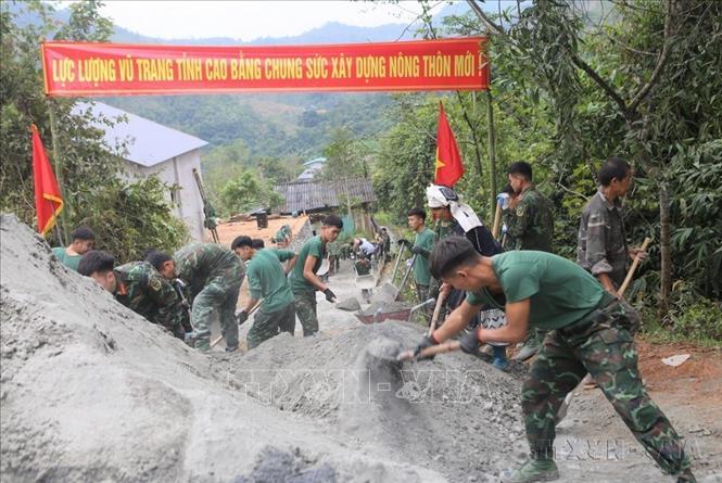 Cán bộ, chiến sĩ Trung đoàn 852 (Bộ Chỉ huy Quân sự tỉnh Cao Bằng) giúp dân bê-tông hóa tuyến đường giao thông nông thôn. Ảnh: Chu Hiệu-TTXVN