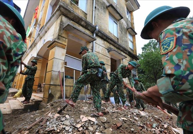 Lực lượng quân đội Quảng Bình tham gia dọn dẹp, vệ sinh môi trường huyện Lệ Thuỷ sau khi trận lũ lịch sử đi qua. Ảnh: TTXVN