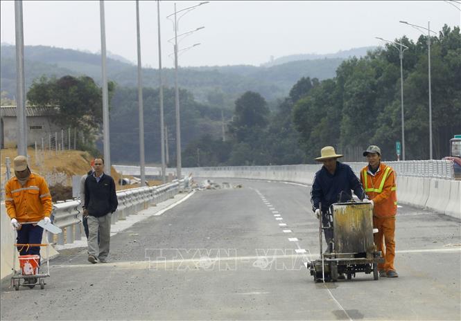 Công nhân sơn kẻ vạch làn đường. Ảnh: Huy Hùng - TTXVN