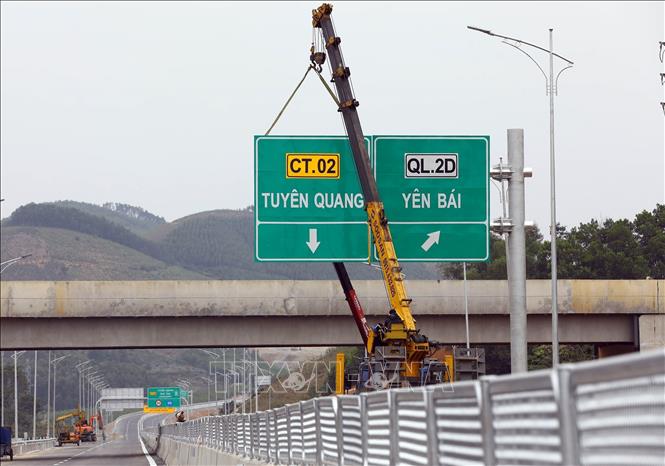 Lắp dựng biển báo giao thông trên tuyến. Ảnh: Huy Hùng - TTXVN
