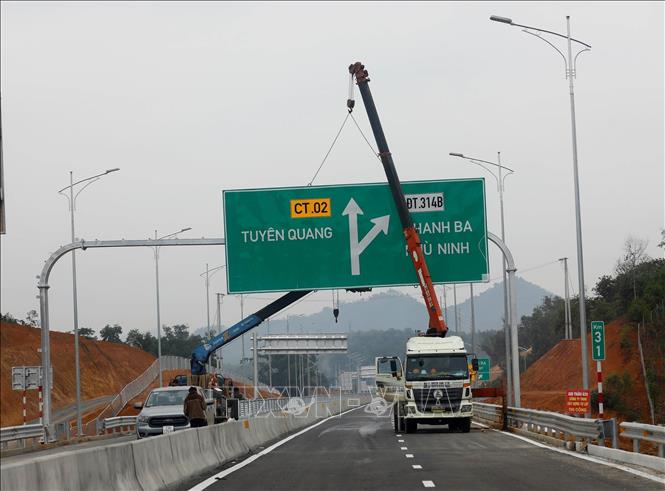 Các nhà thầu đang khẩn trương lắp dựng biển báo giao thông trên tuyến. Ảnh: Huy Hùng - TTXVN