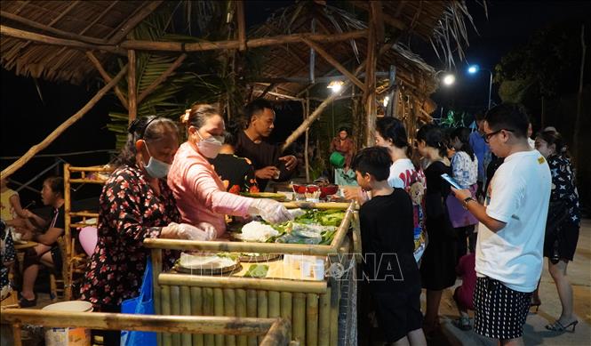 Du khách thưởng thức các món ăn đồng quê tại Chợ quê Tân Thuận Đông (Đồng Tháp). Ảnh: Nhựt An - TTXVN