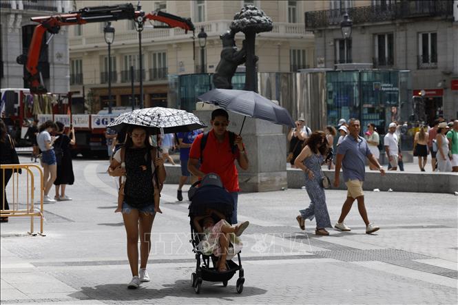 Người dân di chuyển dưới trời nắng nóng gay gắt tại Madrid, Tây Ban Nha ngày 9/8/2023. Ảnh: AFP/TTXVN
