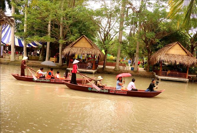 Tourists take boat trips on river in My Khanh village. VNA Photo: Thu Hiền 