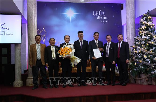 The representative of the Government Committee for Religious Affairs hands over the decision to the Vietnam Baptist Union. VNA Photo: Anh Tuấn