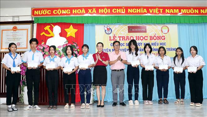 Lãnh đạo huyện Mỹ Xuyên và nhà tài trợ trao học bổng cho học sinh nghèo hiếu học. Ảnh: Trung Hiếu - TTXVN
