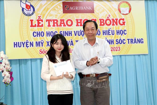 Ông Tạ Đình Nghĩa, Phó Chủ tịch Thường trực Hội nhà báo tỉnh Sóc Trăng trao học bổng khuyến tài cho học sinh xuất sắc. Ảnh: Trung Hiếu - TTXVN
