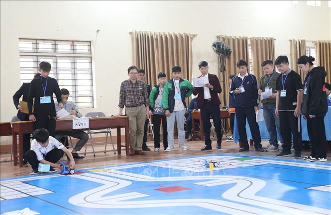 Các đội thi Rô bốt thật, lập trình cho Rô bốt thực hiện các lệnh theo yêu cầu của đề thi trên sân thi đấu (sa bàn). Ảnh: Anh Tuấn – TTXVN