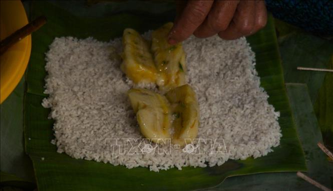Công đoạn gói bánh đòi hỏi sự khéo léo để cho ra thành phẩm đẹp mắt. Ảnh: Nguyễn Hằng - TTXVN