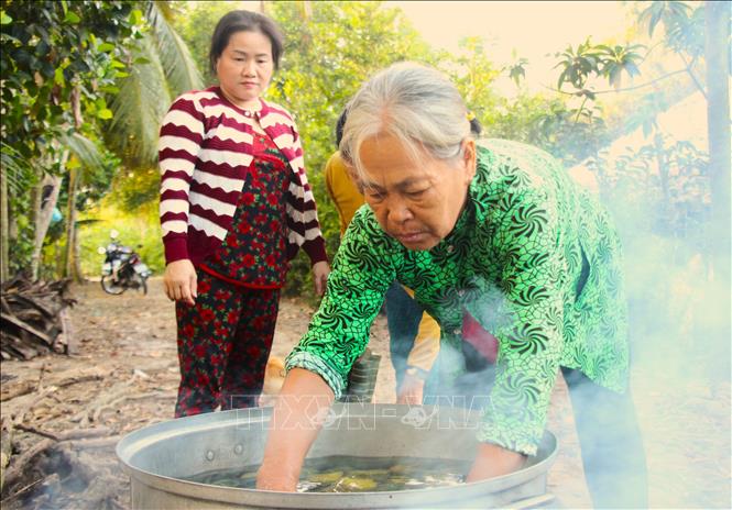 Kinh nghiệm làm bánh Tét được trao truyền, tiếp nối giữa các thế hệ. Ảnh: Nguyễn Hằng - TTXVN