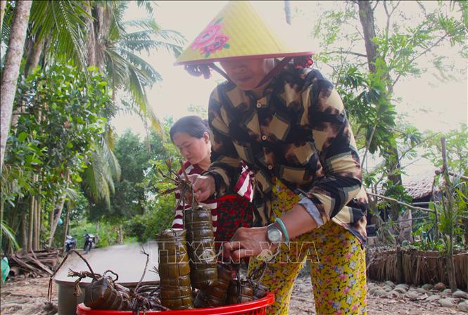 Bánh Tét được vớt sau hơn nửa ngày nấu trên bếp. Ảnh: Nguyễn Hằng - TTXVN
