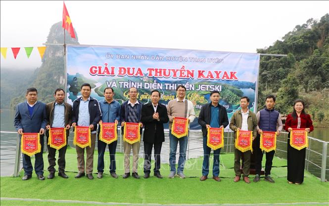 Phó Chủ tịch UBND huyện Than Uyên, Trưởng Ban Tổ chức giải Trần Quang Chiến trao cờ lưu niệm cho các đội thi. Ảnh: Việt Hoàng - TTXVN