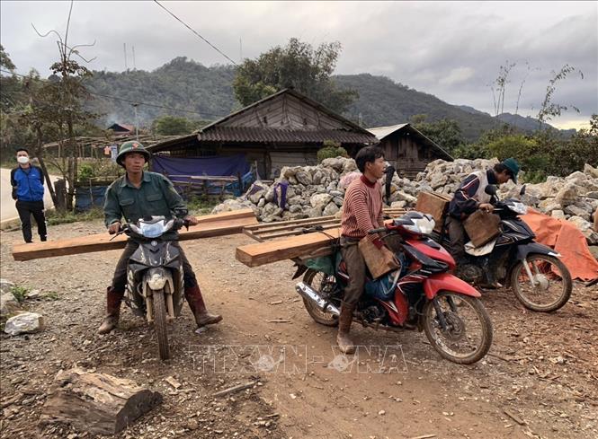Người dân hỗ trợ lực lượng kiểm lâm vận chuyển gỗ trong rừng ở xã Phìn Hồ mà 