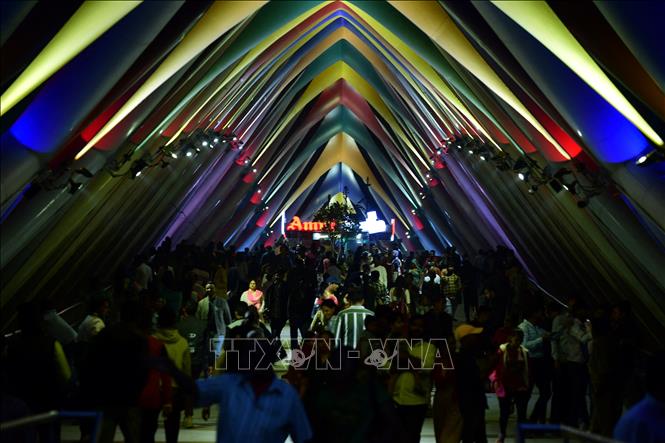 Người dân chờ đón Năm mới trên cây cầu đi bộ Atal bắc qua sông Sabarmati ở Ahmedabad, Ấn Độ, ngày 31/12/2023. Ảnh: AFP/TTXVN