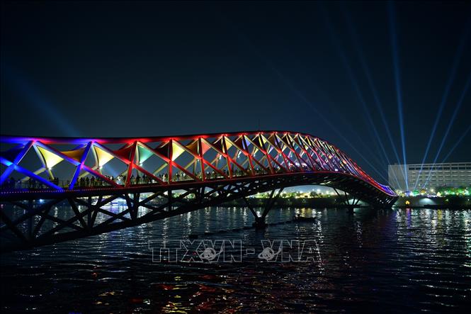 Cây cầu đi bộ Atal bắc qua sông Sabarmati ở Ahmedabad, Ấn Độ, được thắp sáng rực rỡ chờ đón Năm mới, ngày 31/12/2023. Ảnh: AFP/TTXVN