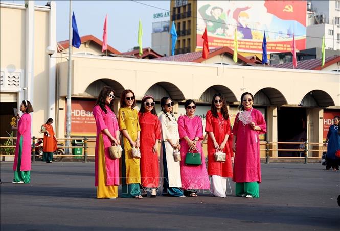 Người dân, khách du lịch chụp ảnh kỷ niệm trước Chợ Bến Thành nhân dịp đầu năm mới 2024. Ảnh: Hồng Đạt - TTXVN
