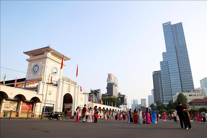 Người dân, khách du lịch chụp ảnh kỷ niệm trước Chợ Bến Thành nhân dịp đầu năm mới 2024. Ảnh: Hồng Đạt - TTXVN
