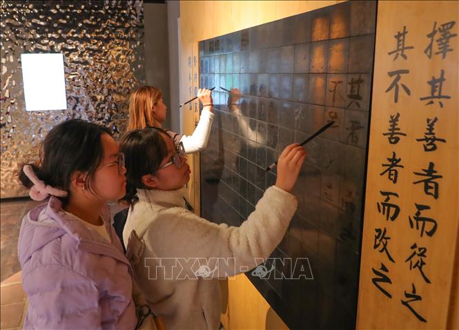 Du khách tham gia hoạt động trải nghiệm tại Văn Miếu-Quốc Tử Giám. Ảnh: Hoàng Hiếu - TTXVN