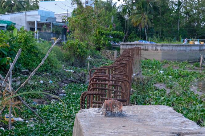 Một đoạn kè rạch Cái Sơn thi công dở dang, trơ vỉ sắt. Ảnh: Thanh Liêm - TTXVN