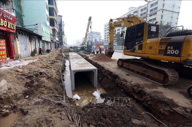 Thi công hệ thống thoát nước trên vỉa hè đường Kim Đồng. Ảnh: Huy Hùng - TTXVN