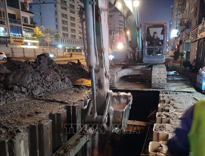 Nhà thầu thi công xén vỉa hè đường Kim Đồng vào buổi đêm. Ảnh: Huy Hùng - TTXVN