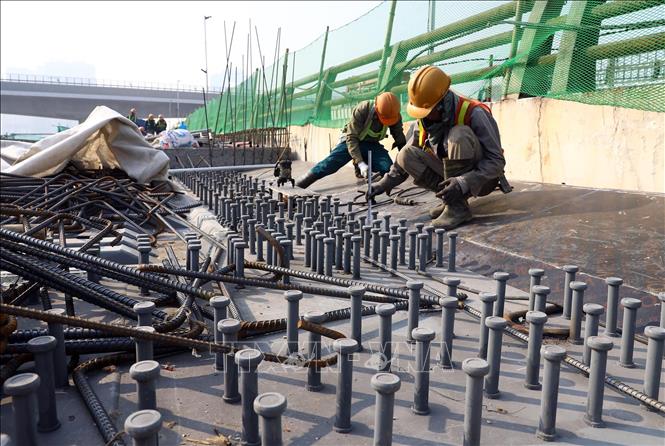 Công nhân đang tiến hành thi công hạng mục bản mặt cầu. Ảnh: Huy Hùng - TTXVN 