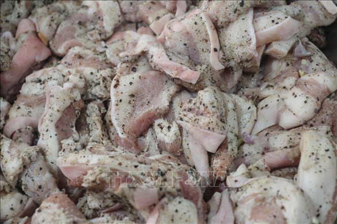 Thịt lợn ba chỉ được ướp hạt tiêu làm nhân bánh chưng. Ảnh: Bích Huệ - TTXVN