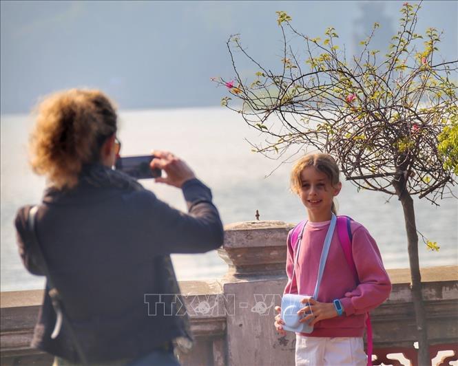 Foreign tourists check in at Ngoc Son Temple in Hanoi. VNA Photo