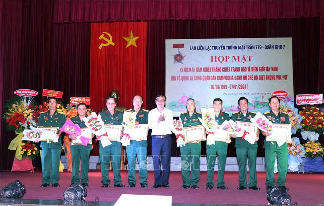 Thiếu tướng Nguyễn Minh Hoàng (giữa), Chủ tịch Hội Cựu chiến binh Thành phố Hồ Chí Minh tặng Bằng khen cho các cá nhân có thành tích trong xây dựng Ban liên lạc truyền thống Hội cựu chiến binh Mặt trận 779. Ảnh: Xuân Khu-TTXVN