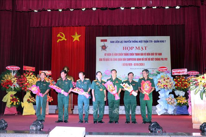Đại tá Hà Xuân Thành (giữa), Trưởng Ban liên lạc truyền thống Mặt trận 779 tặng hoa tri ân đại diện tập thể, cá nhân có thành tích trong xây dựng và phát triển Hội cựu chiến binh Mặt trận 779. Ảnh: Xuân Khu-TTXVN