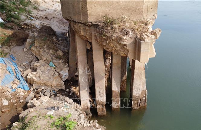 Mực nước xuống thấp lộ ra phần chân trụ cầu với các khối bêtông, thép, đá còn lại khá trơ trọi. Ảnh: Tạ Toàn - TTXVN