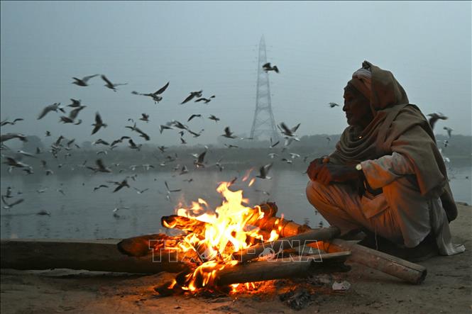 Người dân đốt lửa sưởi ấm trên bờ sông Yamuna ở New Delhi, Ấn Độ, ngày 5/1/2024. Ảnh: AFP/TTXVN