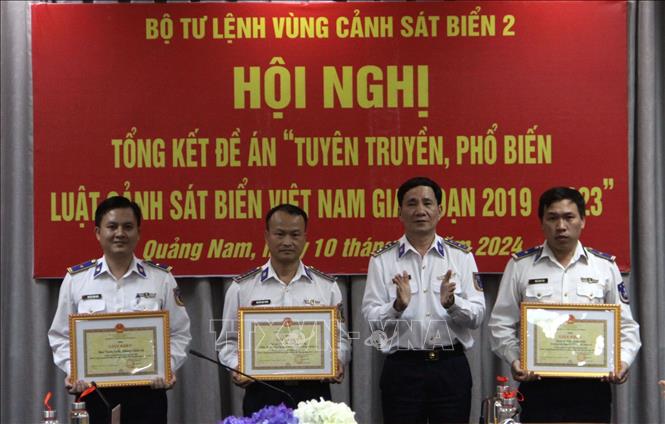 Đại tá Lê Huy Sinh - Chính ủy Bộ Tư lệnh Vùng Cảnh sát biển 2 tặng Giấy khen cho các tập thể và cá nhân thực hiện tốt đề án trong 5 năm qua.  Ảnh: Trịnh Bang Nhiệm - TTXVN
	