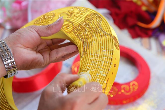 Công đoạn vẽ, trang trí hoạ tiết cho khăn xếp là công đoạn đòi hỏi sự tỉ mỉ, khéo tay từ người thợ. Ảnh: Công Luật-TTXVN