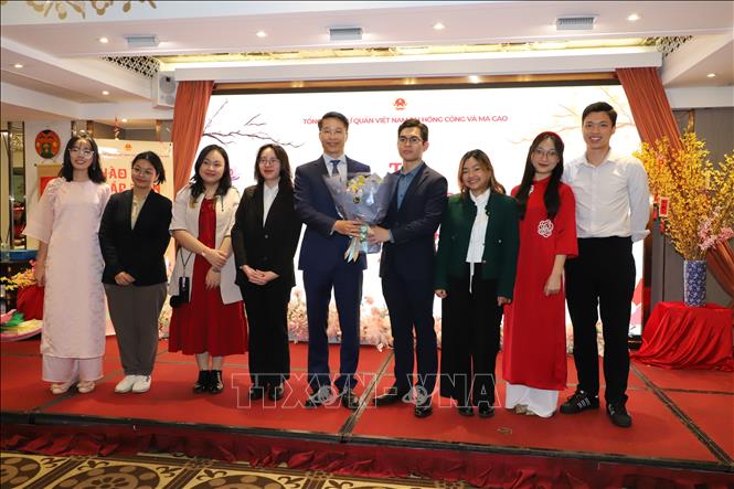 Tổng lãnh sự Phạm Bình Đàm trao hoa cho bạn Nguyễn Đắc Hiếu - tân Chủ tịch Hội sinh viên Việt Nam tại Hong Kong  Ảnh: Xuân Vịnh pv TTXVN tại Hong Kong