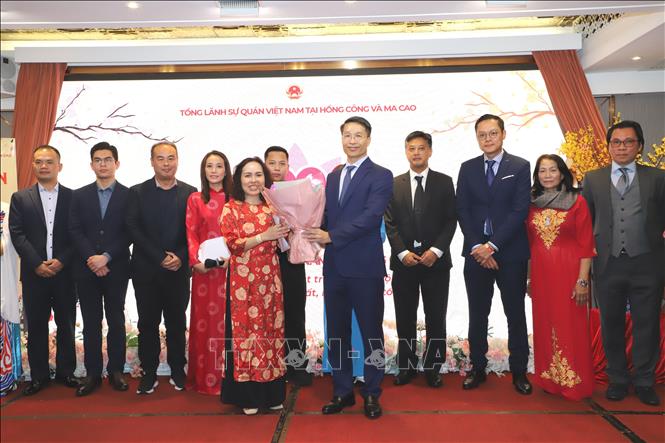 Tổng lãnh sự Phạm Bình Đàm (bên phải) trao hoa cho luật sư Doãn Quỳnh Linh - Chủ tịch Hiệp hội người Việt Nam tại Hong Kong nhân dịp hiệp hội ra mắt cộng đồng Ảnh: Xuân Vịnh pv TTXVN tại Hong Kong