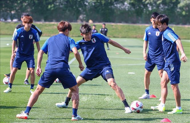Hậu vệ Tomiyasu (Nhật Bản) tranh bóng trong bài tập chuyền bóng 1 chạm. Ảnh: Hoàng Linh/TTXVN
