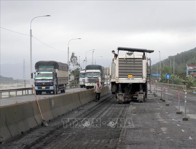 Vị trí mặt đường hư hỏng được cào bóc để xử lý nền móng trước khi thảm mới bê tông nhựa. Ảnh: Xuân Triệu - TTXVN
