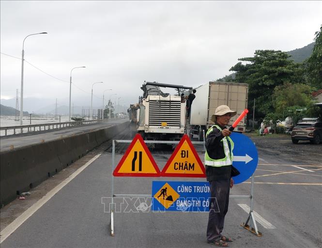 Đơn vị thi công bố trí công nhân gác chắn để điều tiết giao thông qua vị trí sửa chữa. Ảnh: Xuân Triệu - TTXVN